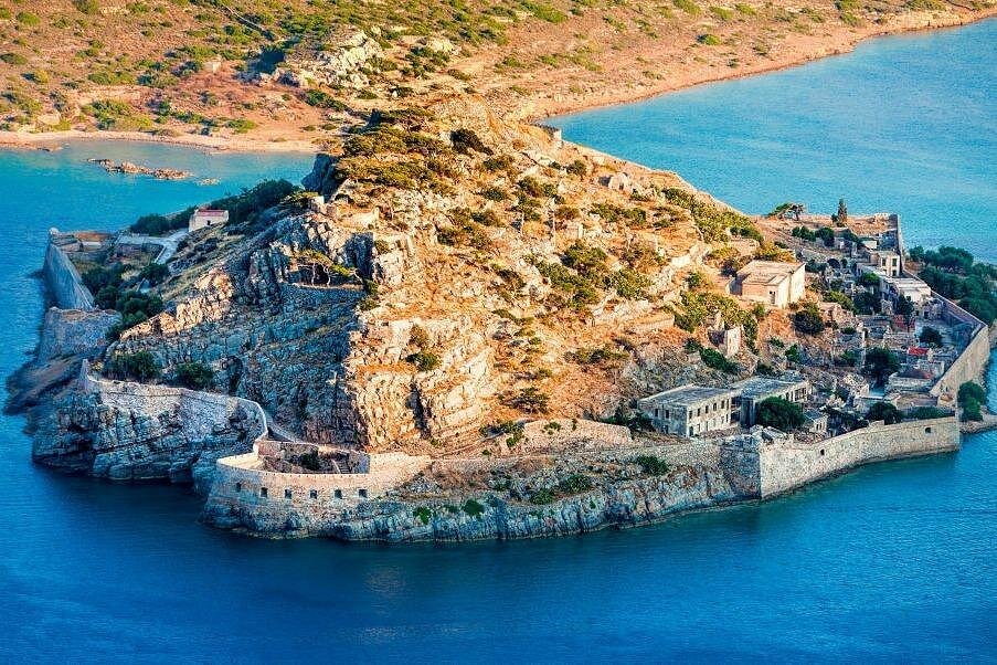 Spinalonga vanuit de lucht, met vestingmuren en oude gebouwen omringd door blauw water