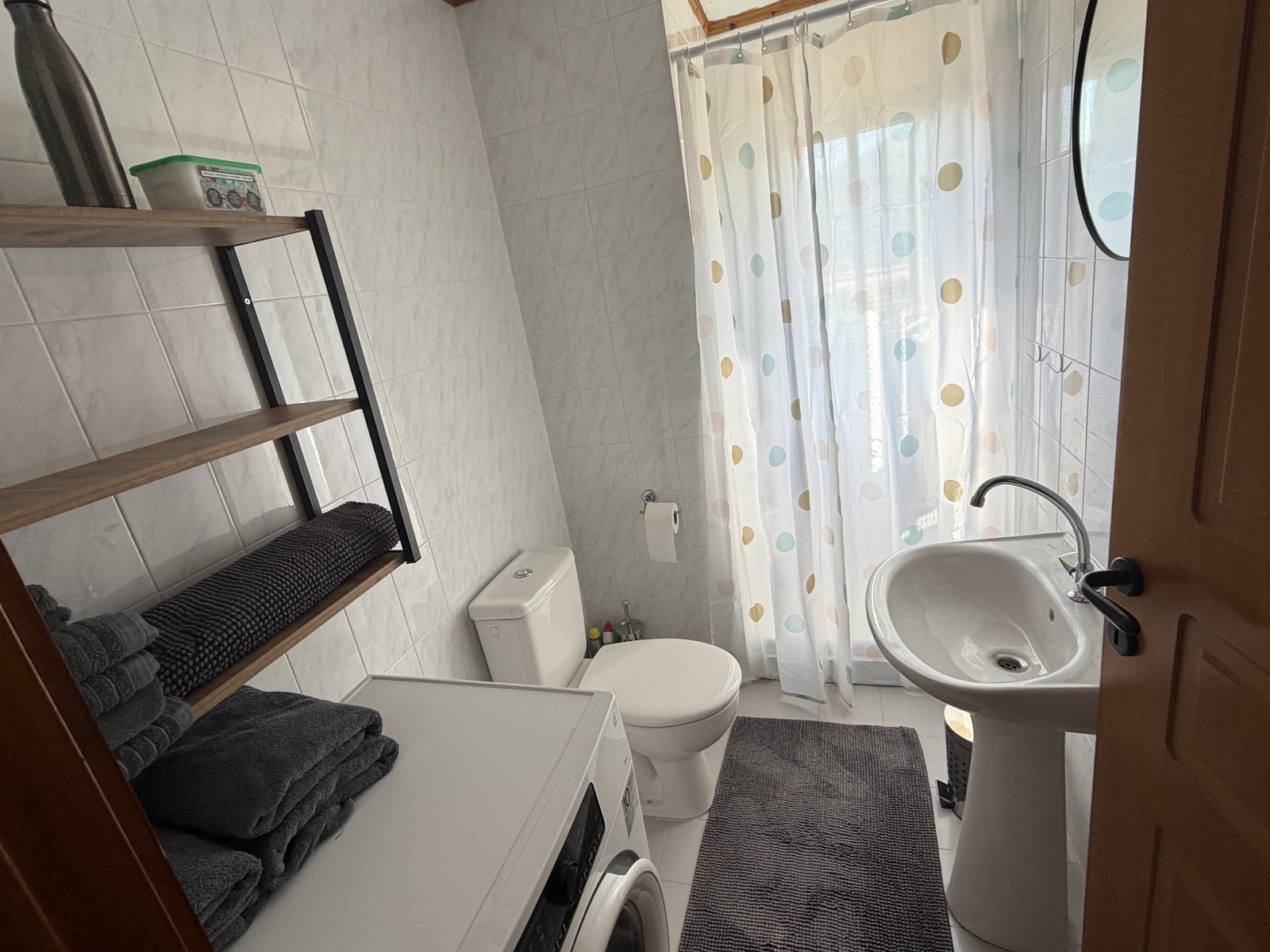 Badkamer met douche en wasmachine